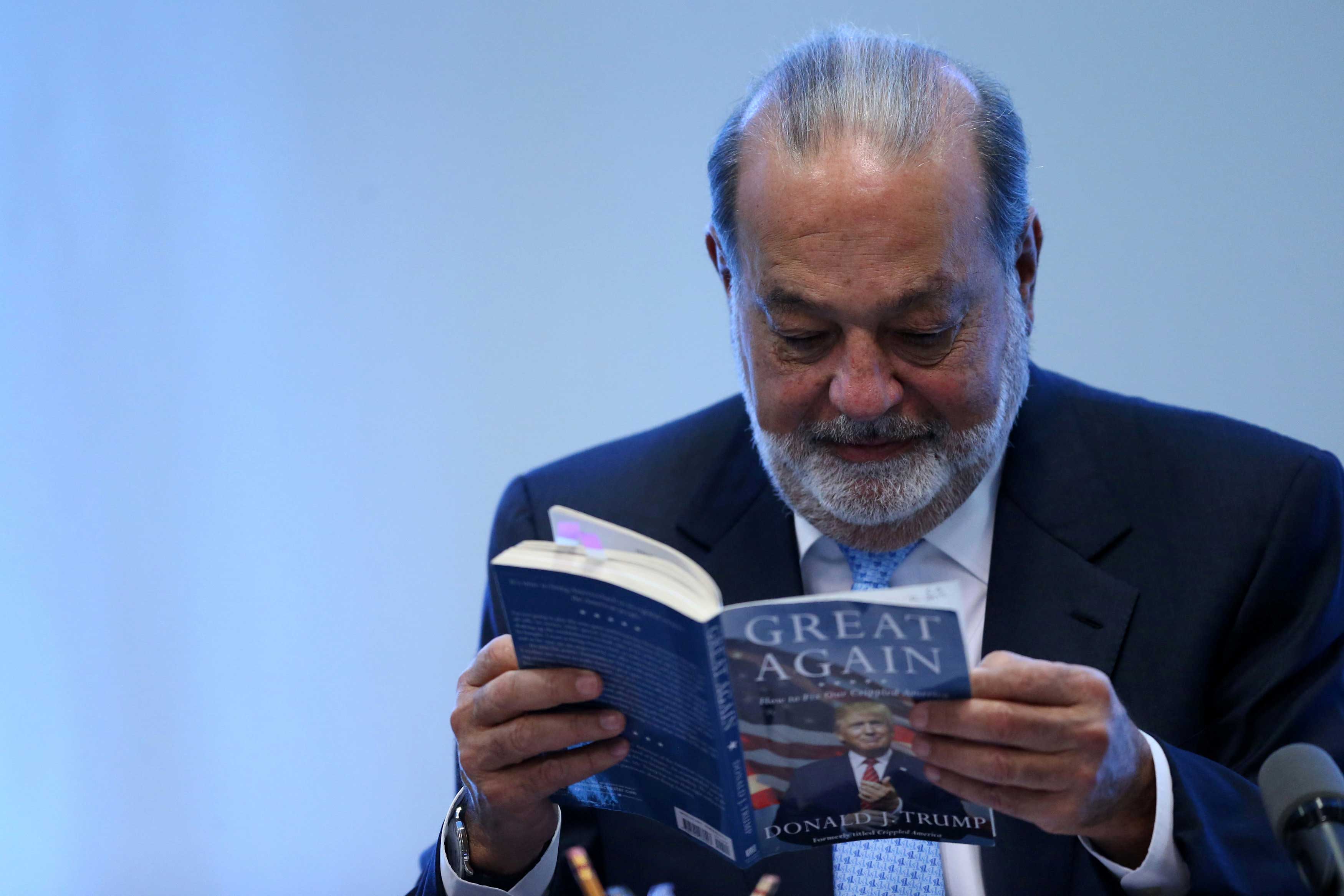 Carlos Slim lee el libro de Donald Trump, en conferencia en la Ciudad de México. Foto de Reuters