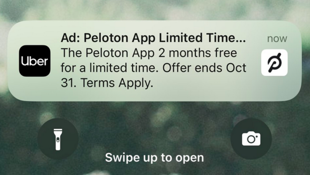 Notificación móvil de Uber con publicidad de Peloton, una compañía que fabrica artículos de entrenamiento. Imagen original de Michelle Grant y vista en Gizmodo